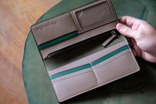 Custom long wallet held open, Buttero Gray and green interior, Horween Dark Green shell cordovan